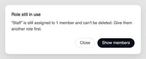 The “Role still in use” window: “Staff” is still assigned to 1 member and can't be deleted. Give them another role first. Below it “Close” and “Show members”.